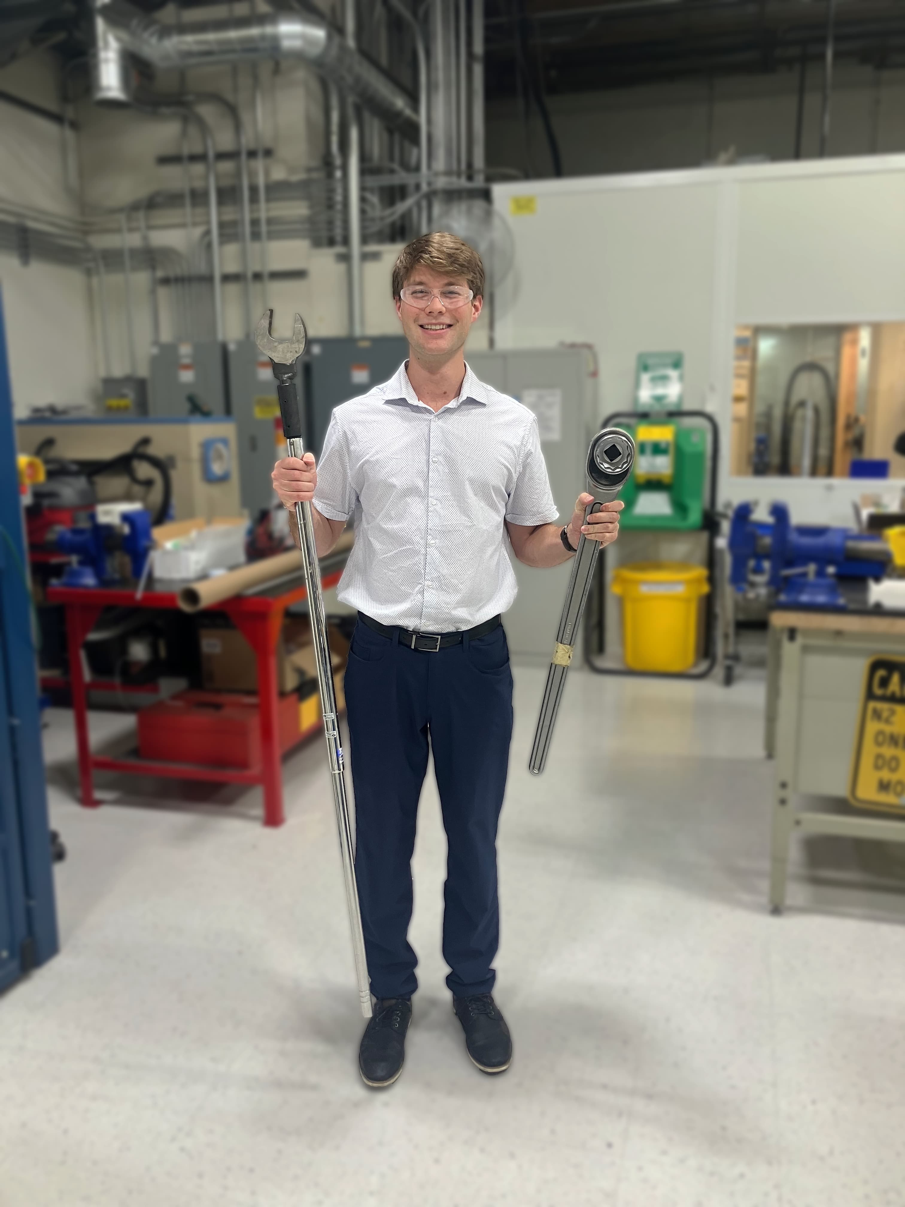 Joseph Hall posing with torque wrenches used before hydrostatic testing